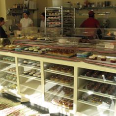 people working behind the counter at a bakery