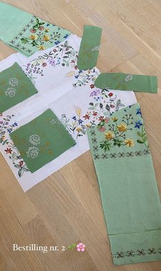 the pieces of fabric are laid out on the floor to make a flowered table runner