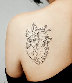 a woman's shoulder with a heart tattoo on it