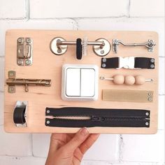 a person holding a wooden board with various items on it