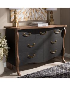 a black and gold dresser with drawers in the middle of it, next to a lamp