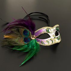 The masquerade mask comes in Mardi Gras for women and the peacock inspired purple green mask for women has arching feathers. This masquerade mask is great for any occasion. Luxury Artistic Masks For Mardi Gras, Adjustable Masquerade Mask For Mardi Gras, Mardi Gras Masks And Prosthetics, Green Masquerade Mask For Mardi Gras, Green Masquerade Mask For Mardi Gras Party, Multicolor Masquerade Mask For Halloween Party, Green Masks For Carnival Costume Party, Green Masks For Mardi Gras Carnival, Mardi Gras Costume Masquerade Mask