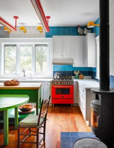 a colorful kitchen with an oven, stove and dining room table in it's center