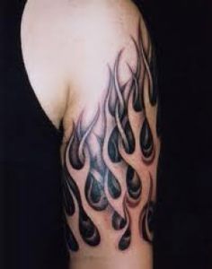 the back of a man's arm with black and grey flames on it