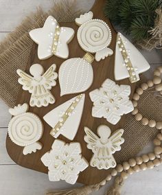 decorated cookies are on a wooden board next to some beads and wood bead necklaces