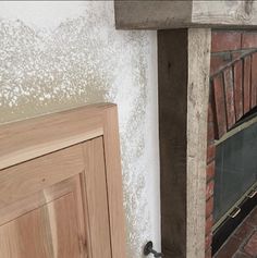 a fire place in the corner of a room next to a door and brick wall