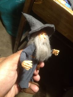 a hand is holding a small wizard figurine