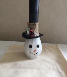 a small white snowman with a black top hat