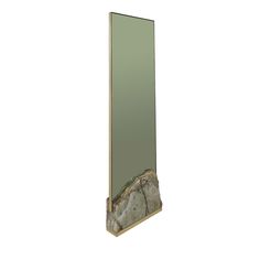 a tall mirror sitting on top of a wooden shelf next to a rock covered wall