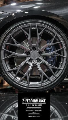 the front wheel of a sports car on display in a showroom with an advertise