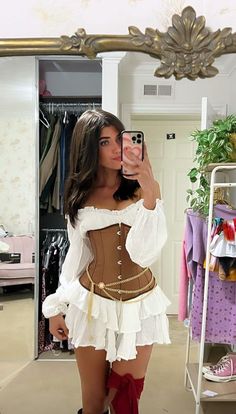 a woman taking a selfie in front of a mirror wearing a corset