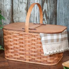 a woven basket sitting on top of a wooden floor next to a potted plant