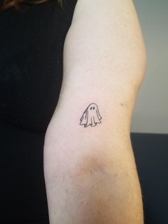 a woman's arm with a small tattoo of a dog on the left side