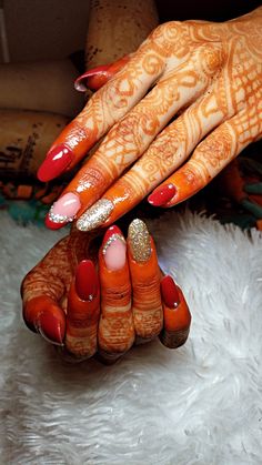 a woman's hands with orange and white designs on them