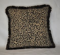 a leopard print pillow with fringe trim