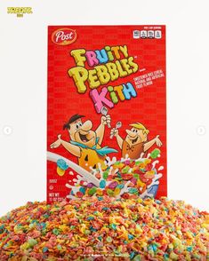 a box of fruity pebbles kit next to a pile of cereal