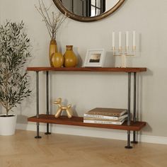 A chic console table displaying a balanced mix of decor, including vases, a candlestick, books, and a metallic dog sculpture, under a round mirror, next to a potted plant, enhancing a modern home interior. Industrial Pipe Furniture, Whiskey Barrel Furniture, Wood Sofa Table, Shoe Rack Entryway, Entrance Table, Barrel Furniture, Entryway Shoe, Pipe Furniture, Industrial Pipe