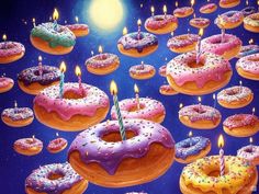 many donuts with lit candles are in the air