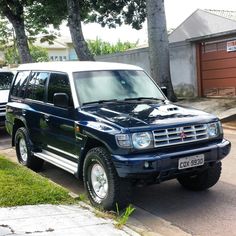 a blue suv parked on the side of a road