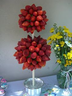 two vases filled with strawberries on top of a table