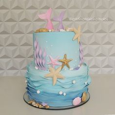 a three tiered cake decorated with starfish and seashells