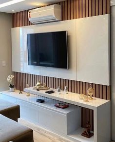 a flat screen tv mounted to the side of a white entertainment center in a living room