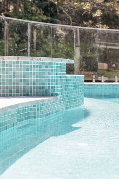 an empty swimming pool with blue tiles on the side and steps leading up to it