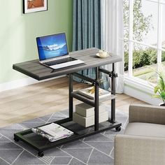 a laptop computer sitting on top of a wooden desk next to a couch in a living room