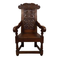 a wooden chair with carvings on the armrests and back rests against a white background