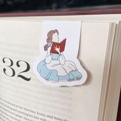 an open book with a sticker on the front and back of it, depicting a woman reading a book