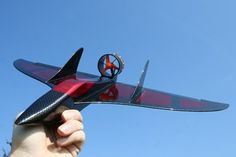 a person holding up a toy airplane in the air