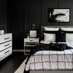 a bedroom with black walls and white furniture