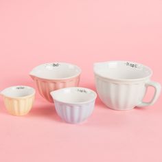 three bowls on a pink background, one has a measuring cup and the other has a measuring cup