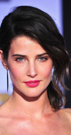 a woman in a strapless dress with pink lipstick on her face and dark hair