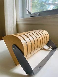 a wooden object sitting on top of a table next to a window