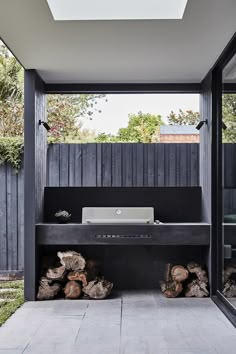 an outdoor grill with wood logs and a laptop on it