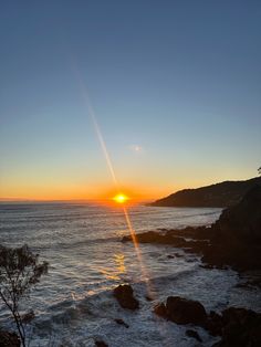 the sun is setting over the ocean with waves