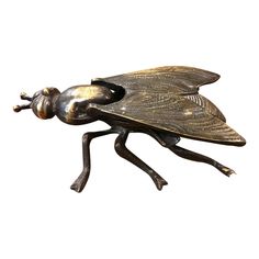 a bronze statue of a fly insect on a white background