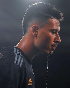 a close up of a soccer player wearing a black shirt and water dripping from his mouth