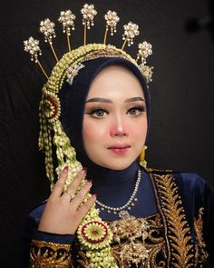 a woman wearing a headdress with pearls and flowers on her head is posing for the camera