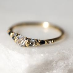 a close up of a ring on a white surface with some rocks in the background