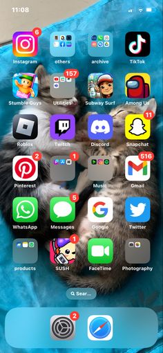 an iphone screen with several different icons on the screen and in front of it is a cat