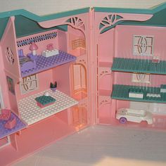 a pink doll house with furniture and accessories