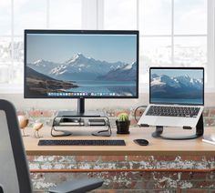 two computer monitors sitting on top of a wooden desk next to a keyboard and mouse