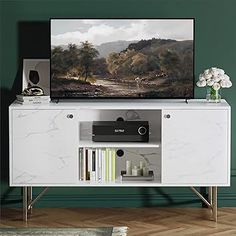 a white entertainment center with a painting on the wall