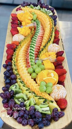 a wooden platter filled with lots of different types of fruits and veggies