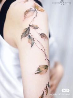 a woman's arm with leaves on it