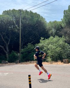 a man running across a parking lot next to trees