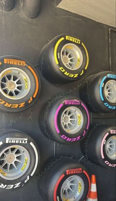 there are many tires on the wall next to each other and one is painted with different colors