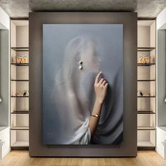 a woman's hand is touching the wall in front of an empty room with shelves and shelving